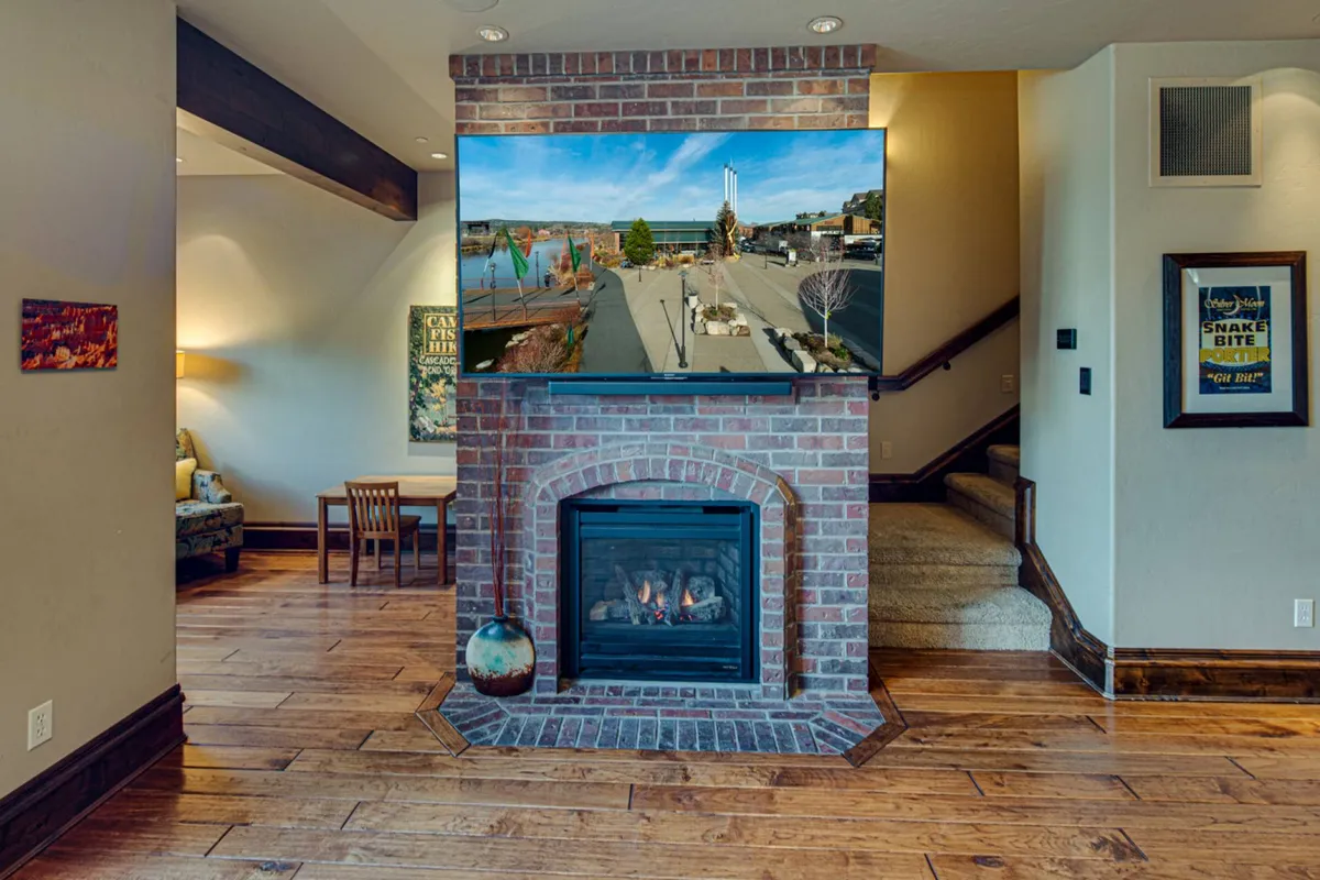 A cozy living area with a fireplace and comfortable seating is shown, with a television mounted nearby. The arrangement suggests a welcoming setting for relaxing evenings, whether by the fire or together for movie nights.